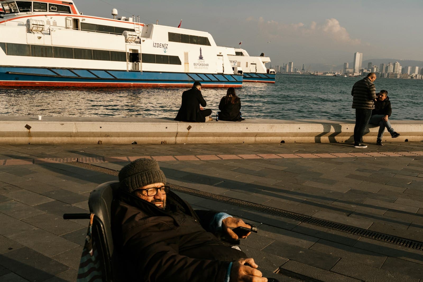A person using a powered wheelchair moving confidently through a bright public space.